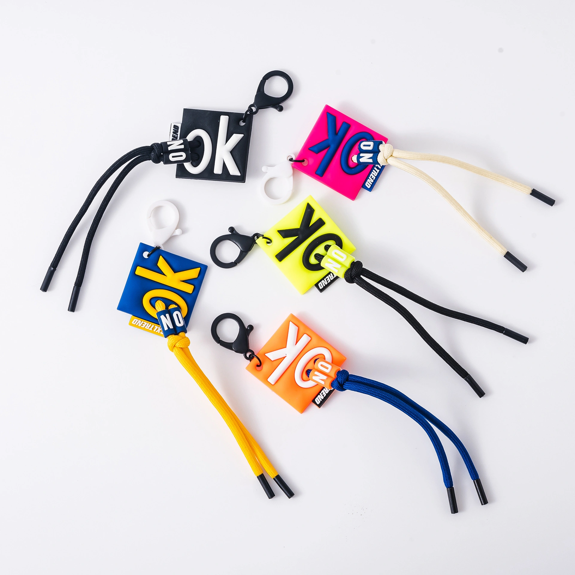 OK letters square tag charm on a knotted cord
